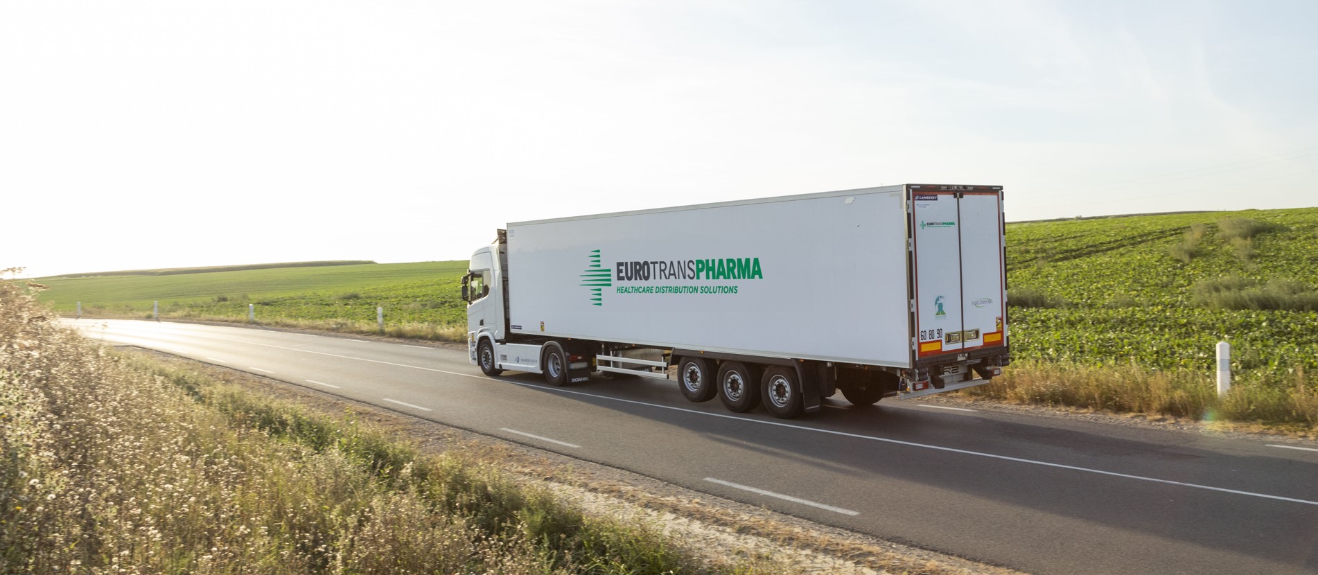 Eurotranspharma temperature-controlled semi-trailer driving through a rural landscape, representing sustainable healthcare distribution across regional and national networks.